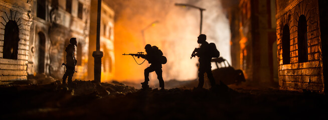 Wall Mural - War Concept. Battle scene on war fog sky background, Fighting silhouettes Below Cloudy Skyline at night. City destroyed by war