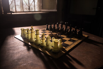 Wall Mural - Chess board game concept of business ideas and competition and strategy ideas concep. Chess figures on a dark background with smoke and fog. Selective focus