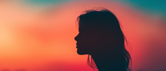 Wall Mural -  A woman's silhouetted head against an orange and pink backdrop with a soft, blurred background