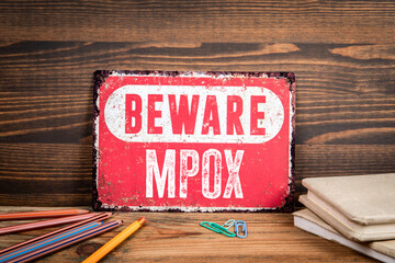 MPOX. Beware sign with text on a wooden texture office table