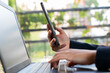 © FATIR29 - A person is typing on a laptop while holding a cell phone in their hand