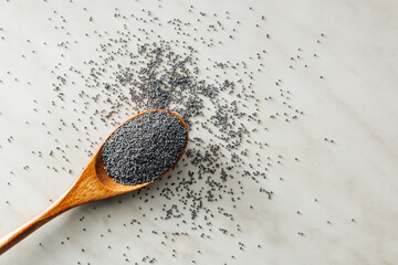 Canvas Print - Dry poppy seed in spoon on kitchen table. Top view.