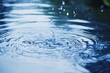 © StockUp - An intricate image of a water droplet creating ripples in a clear blue pool, symbolizing tranquility and simplicity of nature.