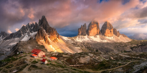 Wall Mural - aerial view of mountains with house and church at sunset in spring. top view from drone of high rock