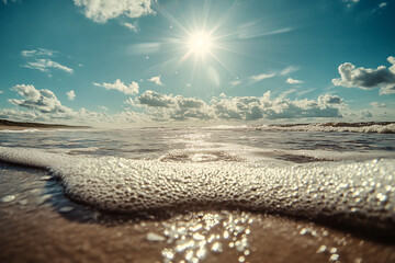 Bright sunlight reflects on ocean waves rolling toward a sandy beach creating a serene and bright coastal landscape