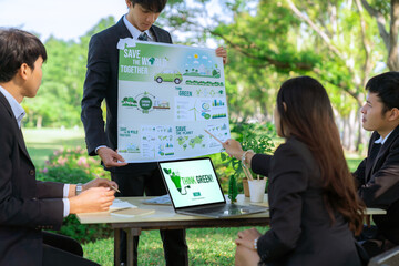 Wall Mural - Group of asian business people presenting environmentally friendly development plan and sustainable technology project for greener future, establishing outdoor eco business office at natural park.Gyre