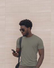 A man stands casually engaged with his phone outside in a vibrant shirt