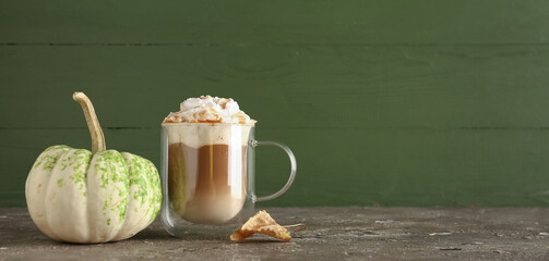 Wall Mural - Glass cup of tasty pumpkin latte on grey table