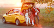 © Pixel-Shot - Parents with little daughter and cute dog sitting in car trunk