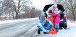 © Pixel-Shot - Parents and their little children near broken car on snowy winter day