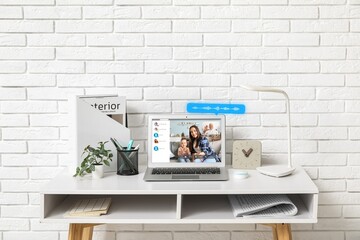 Poster - Interface of software used by people for video chatting on screen of laptop on table