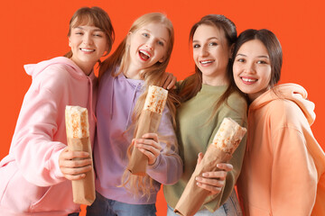 Poster - Young women with doner kebabs on orange background