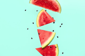 Wall Mural - Flying pieces of fresh watermelon and seeds on turquoise background