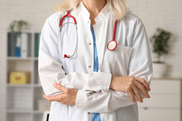 Wall Mural - Female doctor with stethoscope in clinic, closeup