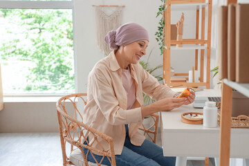 Poster - Mature woman after chemotherapy with bottle of weed sitting at home