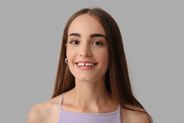 Wall Mural - Young woman with diastema smiling on light background, closeup