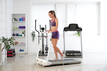 Sticker - Sporty young woman training on treadmill in gym