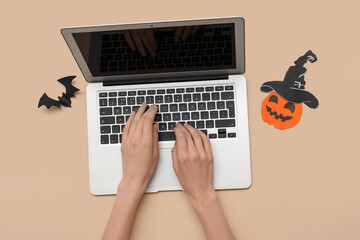 Sticker - Female hands with modern laptop and decor for Halloween on color background