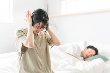 Sticker - ベッドルームで耳を抑える女性と眠る男性（いびき・寝言・睡眠不足・ストレス・うるさい・睡眠障害）
