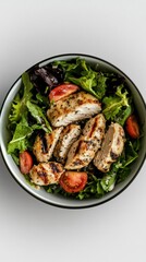 Grilled chicken salad, with mixed greens and balsamic vinaigrette, in a bowl, bright overhead lighting