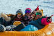 © Hanna - Three friends enjoying a fun day of tubing on snowy slopes during winter