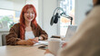 © wattana - Cheerful young woman interviewing her guest while recording podcast.in studio.
