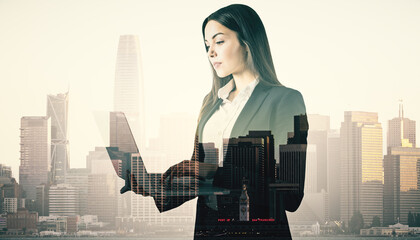 Wall Mural - Attractive young european businesswoman using laptop on abstract blurry city background. Future, success and growth concept. Double exposure.