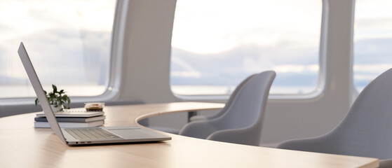 Wall Mural - A side view of a laptop computer on a wooden curved table in a minimalist bright office.