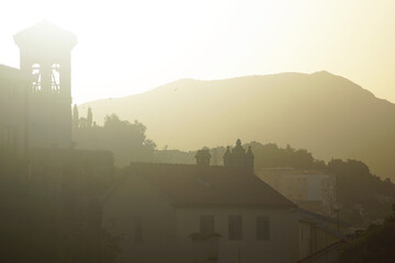 Wall Mural - Morning in the center of Herceg Novi: churches and houses of the Old Town illuminated by the rays of the rising sun against the backdrop of the mountain. View from the fortress Forte Mare (Montenegro)