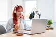 © bongkarn - A beautiful Asian female podcaster is working in her home studio and enjoying a coffee.