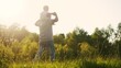 © ibragimova - father carries a little son on his shoulders and walks on the grass in the park. happy family childhood dream concept. a small child sits on the shoulders of his dad man walking in lifestyle field