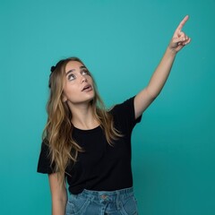 Wall Mural - A beautiful young woman pointing diagonally upwards to the right, isolated on a rich teal background.