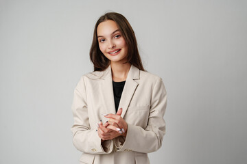 Wall Mural - Smiling Young Woman Against a Grey Background