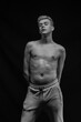 © Tatiana - Young man posing in the dark in the studio