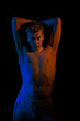 © Tatiana - Young man posing in the dark with red and blue light in the studio