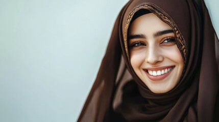 Isolated portrait of a smiling young Arab woman wearing a headscarf