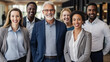 © halo - A diverse group of businesspeople standing together in an office, smiling and looking at the camera with confidence and joy, representing unity among different age groups.