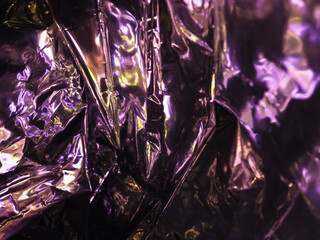 Wall Mural - purple light reflects on silver plastic sheet for abstract dark background.