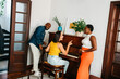 © (JLco) Julia Amaral - Diverse group of friends playing piano and laughing at home in modern living room