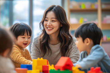 Kindergarten teacher is smiling while playing with children and building blocks