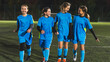 © PoppyPix - cute little girls wearing soccer blue uniforms in a stadium at the practice, full shot night. High quality photo