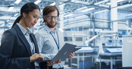Fototapete - Portrait of Experienced Male and Female Engineers Standing in Agency Room, Using Computer Devices and Discussing Production at a Modern Automated Electronics Manufacture with Robot Arms