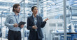 © Gorodenkoff - Two Diverse Engineers Walking in Office, Using Tablet Computer at a Modern Electronics Factory. Female and Male Specialists Chatting, Monitoring Robots on Modern Assembly Line.