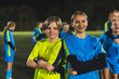 © PoppyPix - school football team goalkeeper girl and her teammate posing for the camera, soccer practice in a stadium. High quality photo
