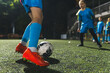 © PoppyPix - closeup shot of a girl playing with a soccer ball in a stadium, evening practice, blue uniforms. High quality photo