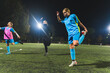 © PoppyPix - full shot of a female coach and young girl heating up before the soccer practice at night. High quality photo