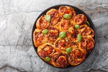 Sticker - Rustic Pizza rolls filled with italian sausages, Mozzarella, tomato and basil closeup on the bakong dish on the table. Horizontal top view from above