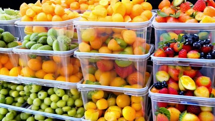 Sticker - Various fruits are neatly arranged in clear containers, showcasing vibrant colors and inviting freshness at a bustling market.