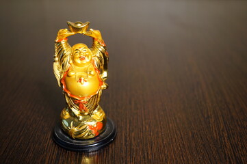 Wall Mural - A statuette of a smiling Buddha on the table.