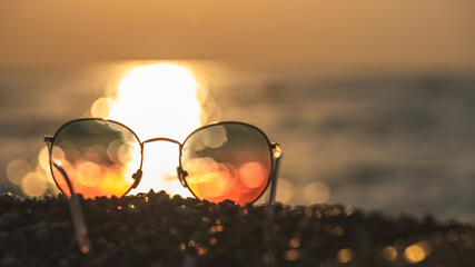 Sunglasses on the background of the sea at sunset, concept summer vacation at the sea